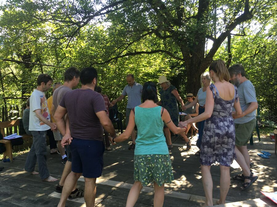 Group singing outdoors under the trees